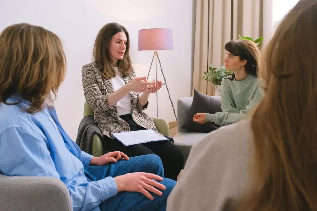 Placement officer counselling two students in a meeting room